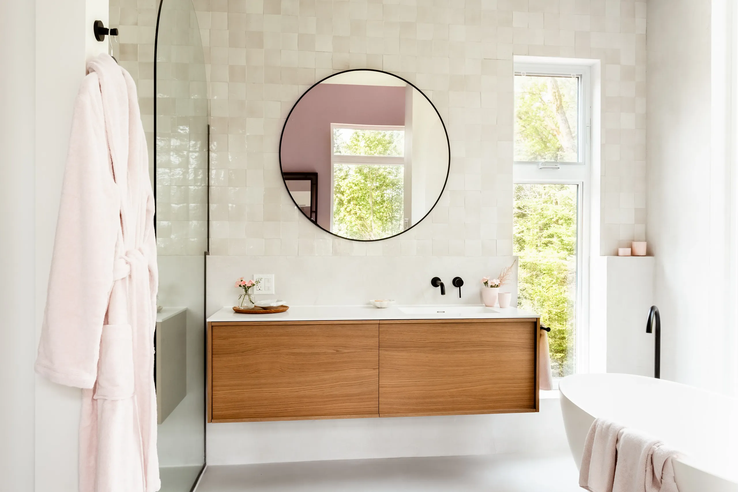 Main bathroom in a Mont-Tremblant chalet — stone wall detail around a freestanding soaking tub.