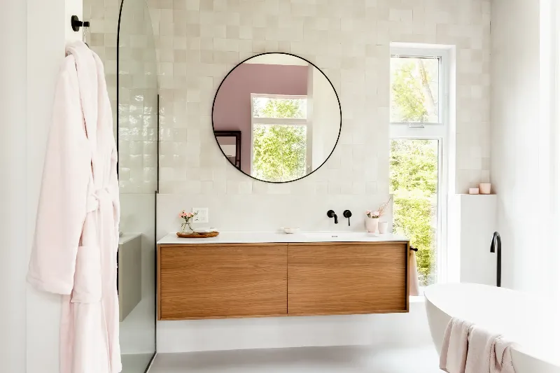 Main bathroom in a Mont-Tremblant chalet — stone wall detail around a freestanding soaking tub.