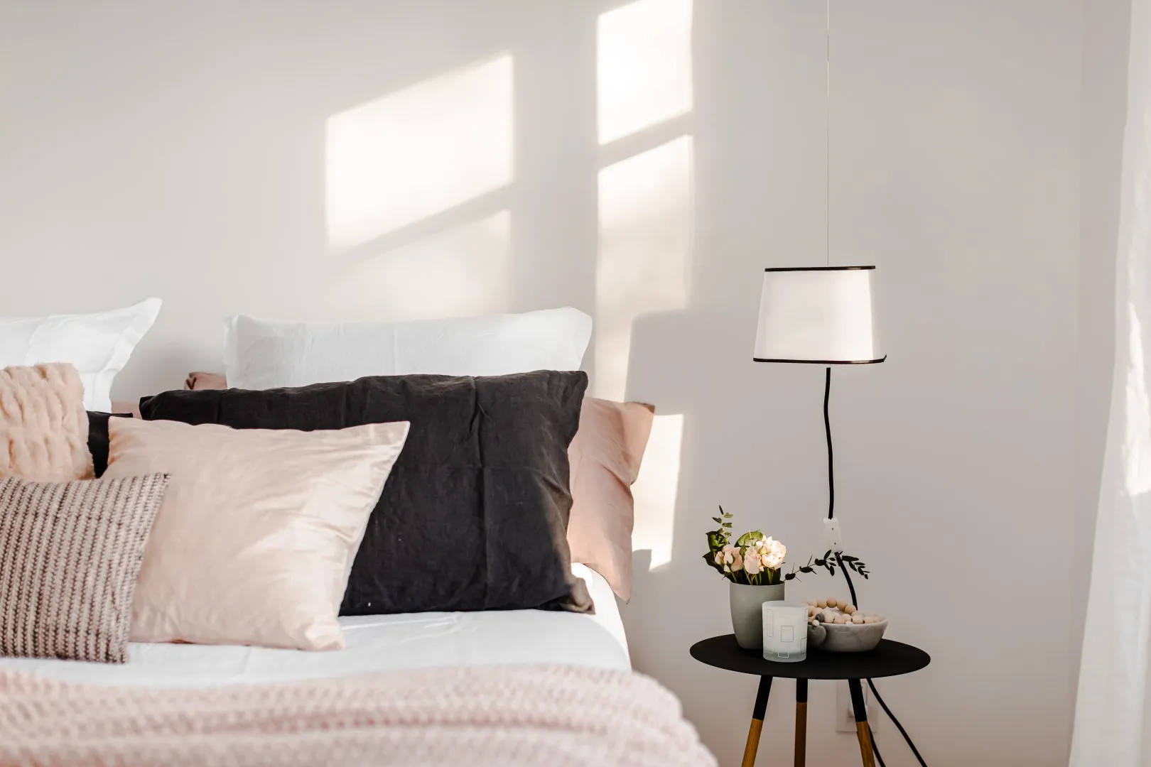 Primary bedroom detail — woven textiles and walnut nightstand, Montreal bungalow.