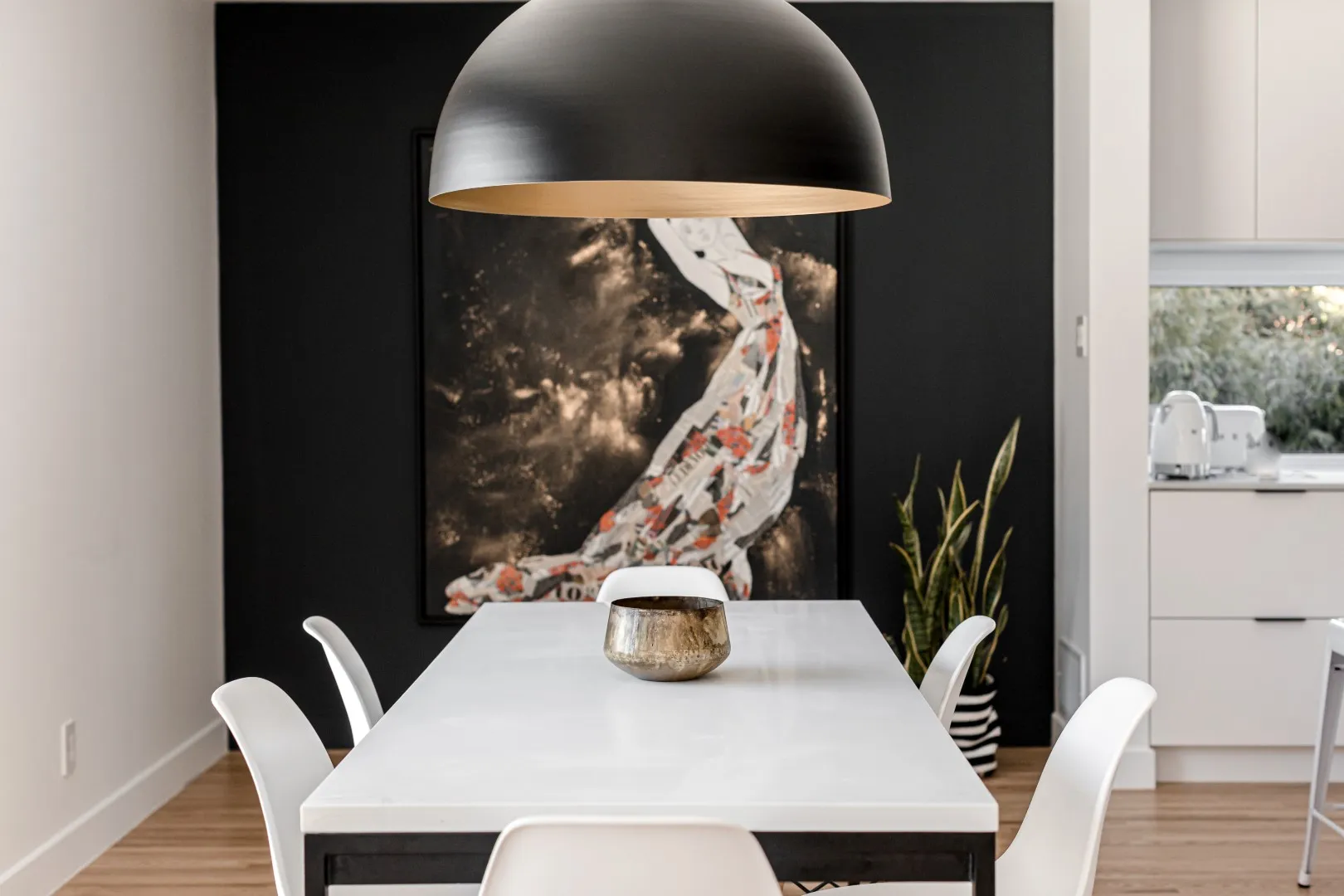 Salle à manger cadrée par un pan de mur anthracite et une œuvre figurative — bungalow de Montréal.