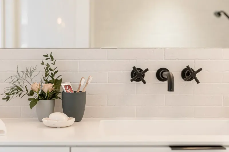 Family bathroom in the Montreal bungalow — tile wall and a natural wood vanity.