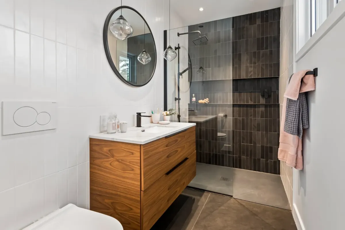 Primary bathroom in the Montreal bungalow — freestanding tub set against a tile feature wall.