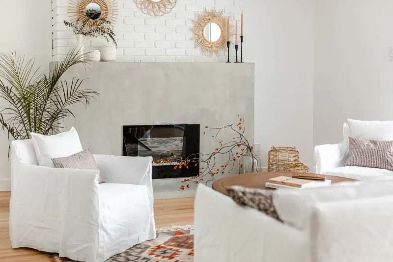 Living room detail — layered linen and kilim under a sculptural brass pendant, Montreal bungalow.