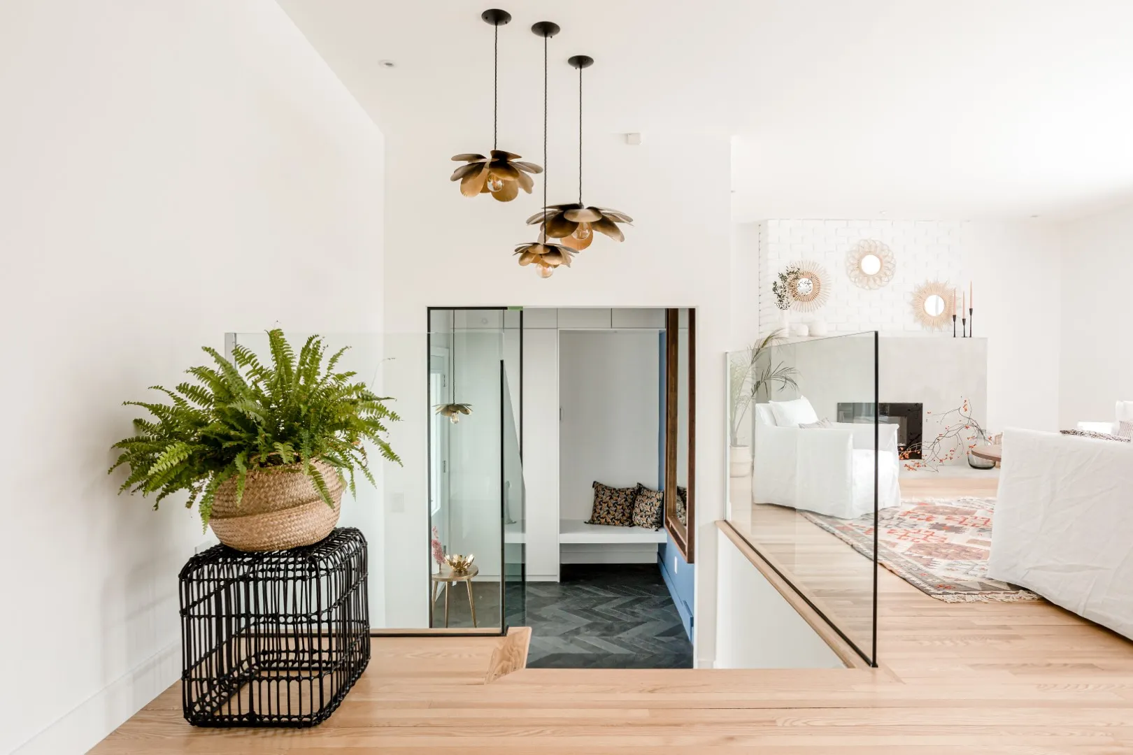 Glass-balustrade staircase opening onto the Montreal bungalow living room.