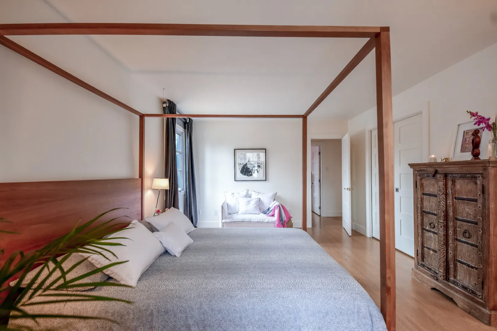 Wide view of the primary bedroom — custom millwork wall, Montreal cottage.