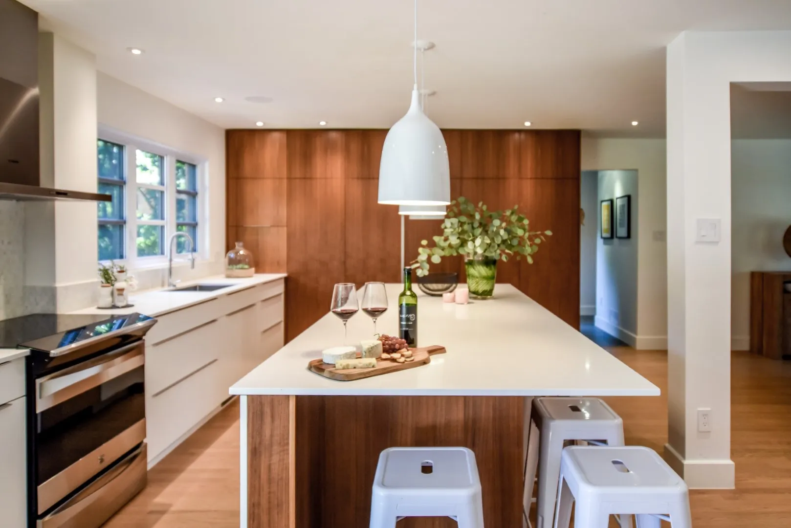 Montreal cottage kitchen — white millwork and walnut accent, integrated refrigerator behind panels.