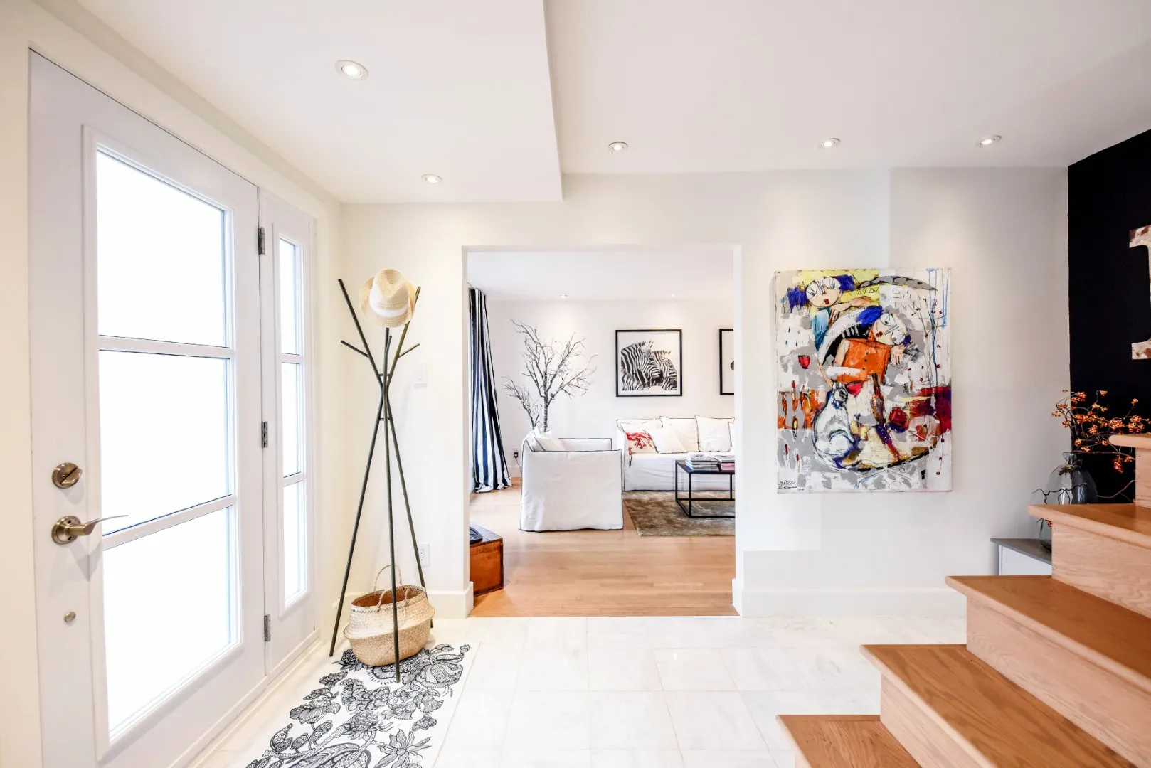 Entry detail with vintage coat tree and straw basket — Montreal cottage.