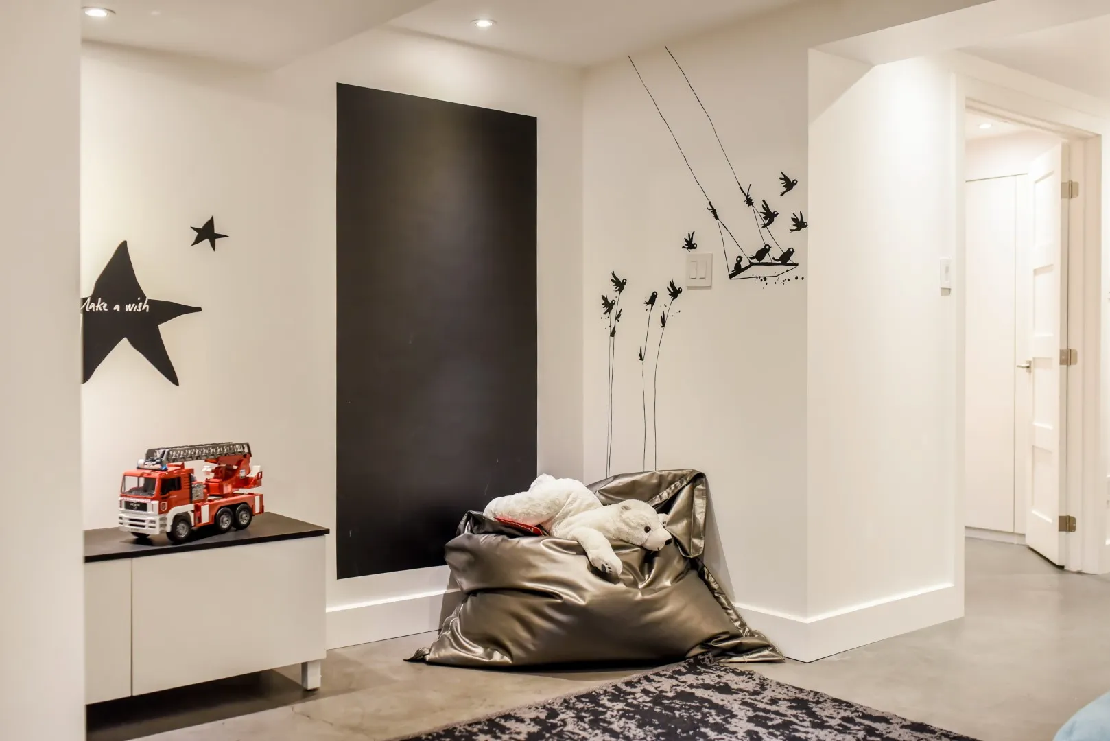 Basement playroom in the Montreal cottage — warm rug and relaxed seating.
