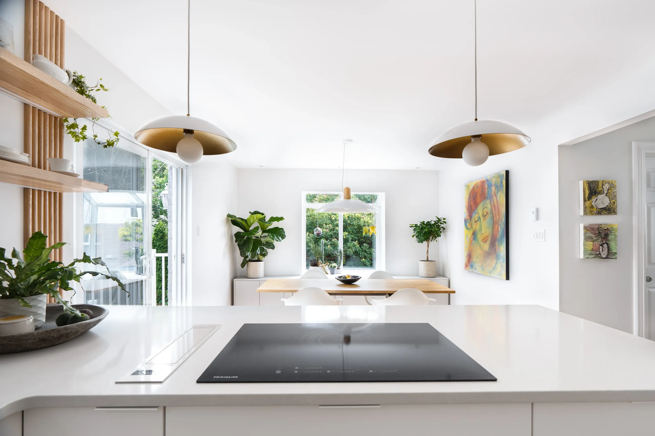 Working side of the Longueuil kitchen — integrated lines, white lacquered cabinetry, and a pale stone counter.