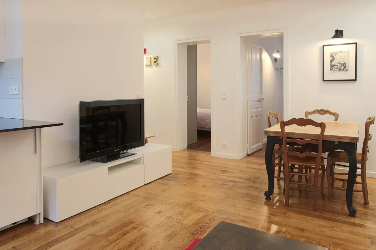 Coin salle à manger dans la location du Paris 16e — table provinciale sur plancher de chêne rafraîchi.