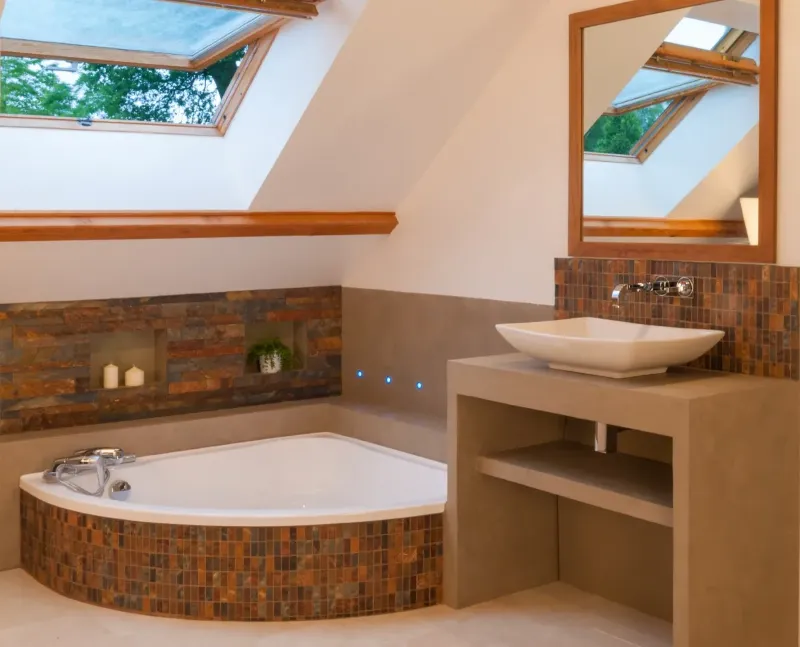 Salle de bain d'une construction neuve à Versailles — mur d'ardoise avec niches rétro-éclairées et pourtour de baignoire en béton ciré.